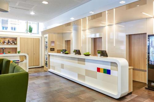 a lobby with a reception desk with a rainbow at Park Inn by Radisson Stuttgart in Stuttgart