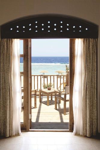 an open door to a balcony with a view of the beach at Radisson Blu Resort El Quseir in Quseir