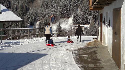 a group of people walking down a street in the snow at Hotel Serenella in Canale San Bovo