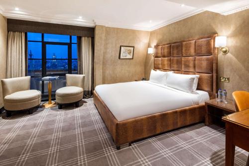Cette chambre comprend un lit et un bureau. dans l'établissement Radisson Blu Edwardian Hampshire Hotel, London, à Londres