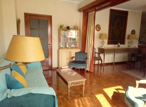 a living room with a blue couch and a table at Casa do Sol in Porto