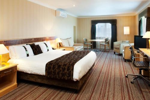 Holiday Inn Barnsley, an IHG Hotel في بارنسلي: غرفه فندقيه سرير كبير وتلفزيون