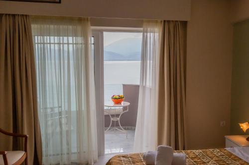 a bedroom with a window with a view of the ocean at Chrisi Akti in Nafpaktos