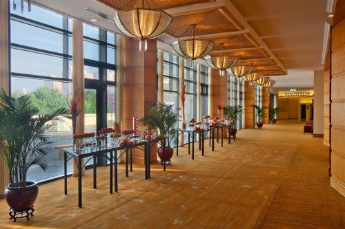a row of tables in a hallway with large windows at Holiday Inn Temple Of Heaven Beijing by IHG in Beijing