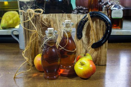 two bottles of apple syrup and apples on a table at Gasthaus & Hotel Drei Lilien in Werbach