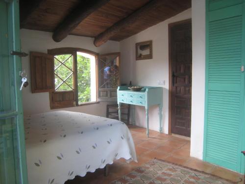 a bedroom with a bed and a desk and a window at Posada del Castaño in Castaño de Robledo