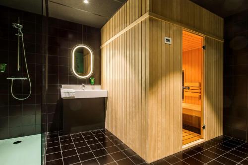 a bathroom with a sink and a shower at Park Inn By Radisson Brussels Airport in Diegem