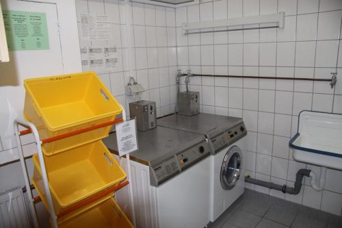 een keuken met een wastafel en een wasmachine bij Ferienwohnungen Landgasthof Gilsbach in Winterberg