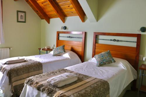 a room with two beds in a room at Hosteria Las Garzas in Villa La Angostura