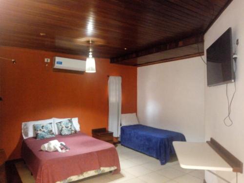 a bedroom with two beds and a tv in it at El Uru Suite Hotel in Puerto Iguazú