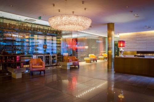 a lobby with chairs and a chandelier in a building at Radisson Blu Media Harbour Hotel, Düsseldorf in Düsseldorf
