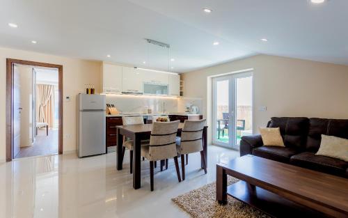 a kitchen and living room with a table and a couch at Villa Višnja Prestige in Brela