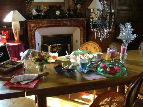 einen Holztisch mit Essen und einem Kamin in der Unterkunft Villa Primerose in Arcis-sur-Aube