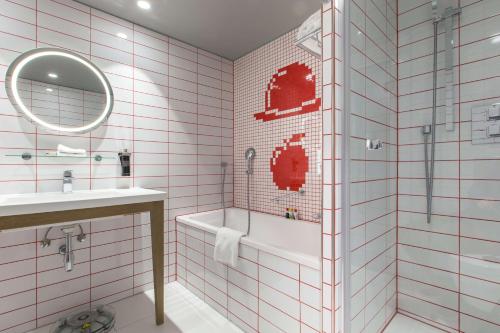 a bathroom with a toilet, sink, and bathtub at Radisson RED Brussels in Brussels