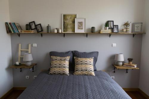 a bedroom with a blue bed with shelves on the wall at Avenida Central - Coimbra Accommodation in Coimbra