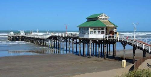 a pier with a building on it on the beach at Ayre del Tuyu in Mar del Tuyú
