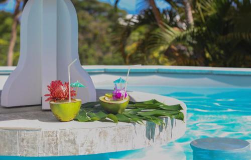 una piscina con due cocktail su un tavolo accanto alla piscina di LES HAUTS DU CAP a Le François