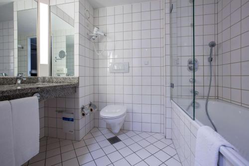 a bathroom with a toilet, sink, and bathtub at Radisson Blu Scandinavia Hotel Aarhus in Aarhus