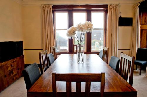 a dining room table with a vase of flowers on it at Springfield guest house in Tain