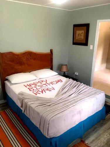 a bedroom with a large bed with red writing on it at Castara Inn in Castara