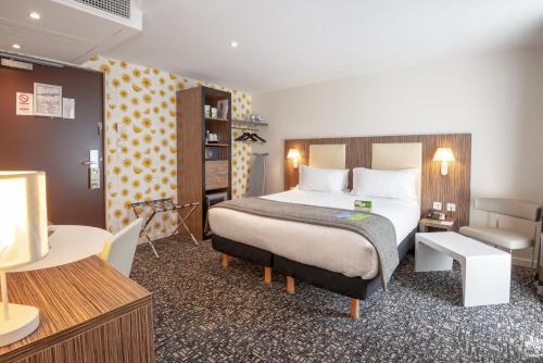 Un pat sau paturi într-o cameră la Holiday Inn Paris Opéra - Grands Boulevards, an IHG Hotel