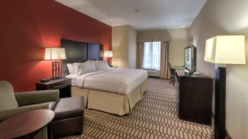 a hotel room with a bed and a television at Holiday Inn North Quail Springs by IHG in Oklahoma City