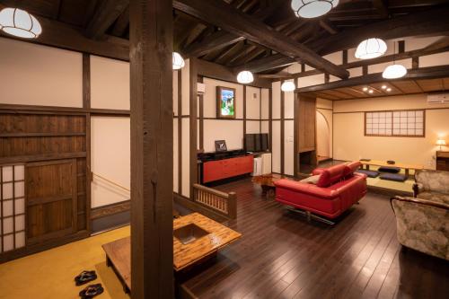 a living room with a red chair and a couch at Sen-no-Mori in Aso