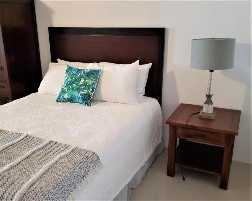 a bedroom with a bed and a table with a lamp at KASA The Lofts 201 HUGE 2 bed 2 bath for 6 Washer Dryer in San Juan
