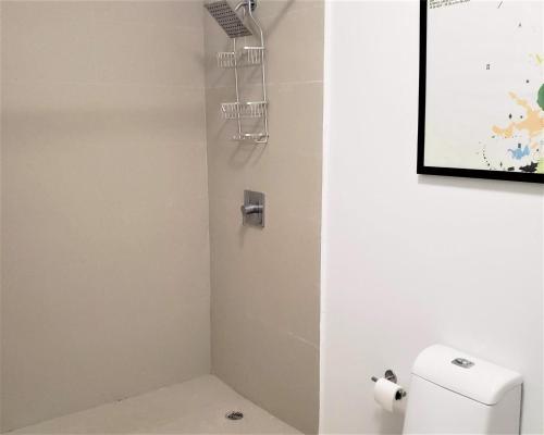 a bathroom with a toilet and a picture on the wall at KASA The Lofts 201 HUGE 2 bed 2 bath for 6 Washer Dryer in San Juan
