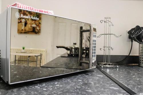 a microwave sitting on top of a counter at Stylish - Modern - Serviced Accommodation - In The Heart of Northumberland in Ashington