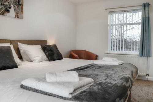1 dormitorio con 2 camas con sábanas blancas y ventana en Stylish - Modern - Serviced Accommodation - In The Heart of Northumberland en Ashington