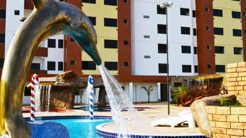 a fountain with a dolphin drinking water from it at Apartamento Golden Dolphin Supreme Caldas Novas in Caldas Novas