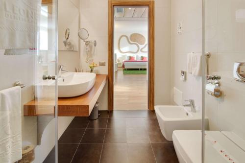 a bathroom with a sink and a toilet and a tub at Best Western Plus Leone di Messapia Hotel & Conference in Lecce