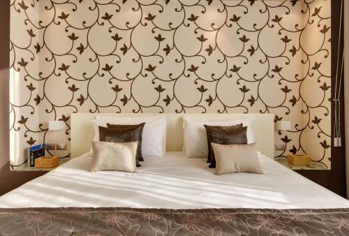 a bedroom with a large white bed with a wall at Best Western Plus Leone di Messapia Hotel & Conference in Lecce