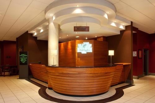 a lobby with a large wooden bar in a building at Holiday Inn Barnsley by IHG in Barnsley