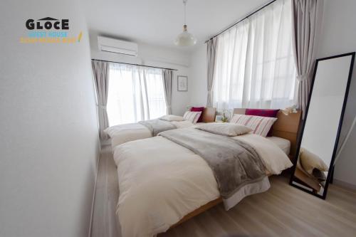 1 dormitorio con 2 camas y ventana grande en GLOCE 逗子ワーケーションハウス なぎさ l ZUSHI Workcation House NAGISA, en Zushi