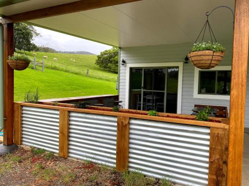 a fence with two baskets on top of a house at Waterfall Unit Farm Stay in Upper Orara