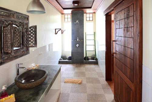 Bahari Villa Tejakula في تيجاكولا: حمام مع حوض أسود ودش