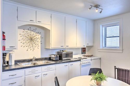 a kitchen with white cabinets and a sink and a table at Beauty in the Black Hills An Upscale Apt in Lead in Lead