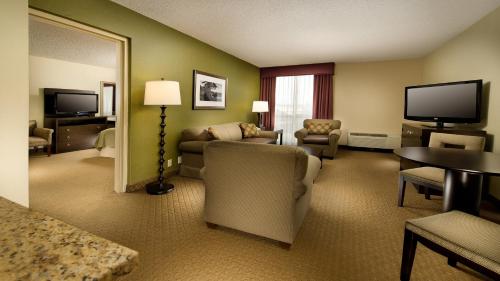 a hotel room with a couch and a television at Holiday Inn Portland-Airport I-205 by IHG in Portland