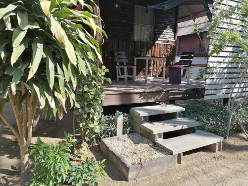a porch of a house with a bench and stairs at Sleep Whale Lanta in Ko Lanta