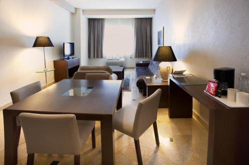 a room with a table and chairs in a hotel room at Holiday Inn Puebla La Noria by IHG in Puebla