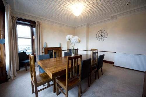 a dining room with a wooden table and chairs at Springfield guest house in Tain