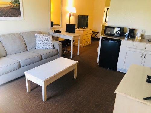 a living room with a couch and a kitchen at Days Inn & Suites by Wyndham Navarre - near Beaches Hurlburt in Navarre
