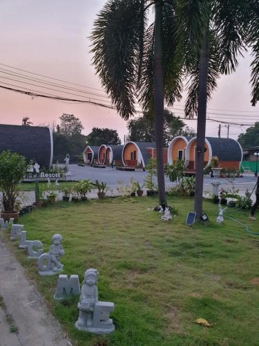a park with concrete statues in front of a building at Tiny hut resort in Bangkok