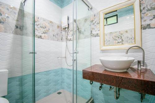 La salle de bains est pourvue d'un lavabo et d'une douche en verre. dans l'établissement TC villa on beach, à Ko Larn