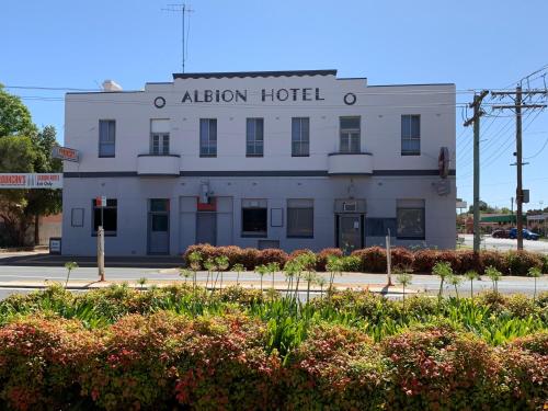 a white building with a sign that reads altar hotel at Albion Motel Finley in Finley