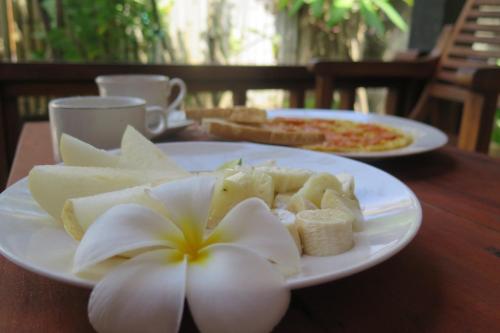 un piatto di cibo con un fiore su un tavolo di Tapada a Gili Air