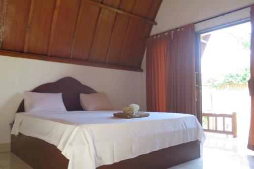 Un dormitorio con una cama con un osito de peluche. en Tapada en Gili Air