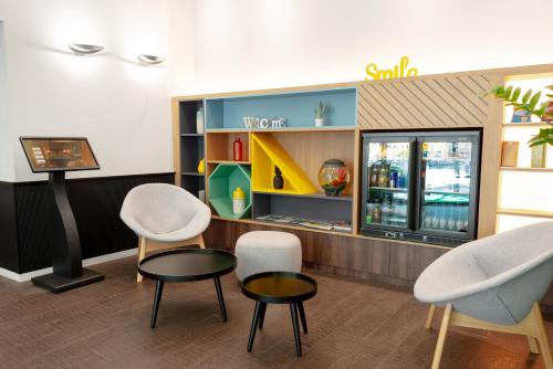 a store with two chairs and a table and a counter at Holiday Inn Paris Opéra - Grands Boulevards by IHG in Paris
